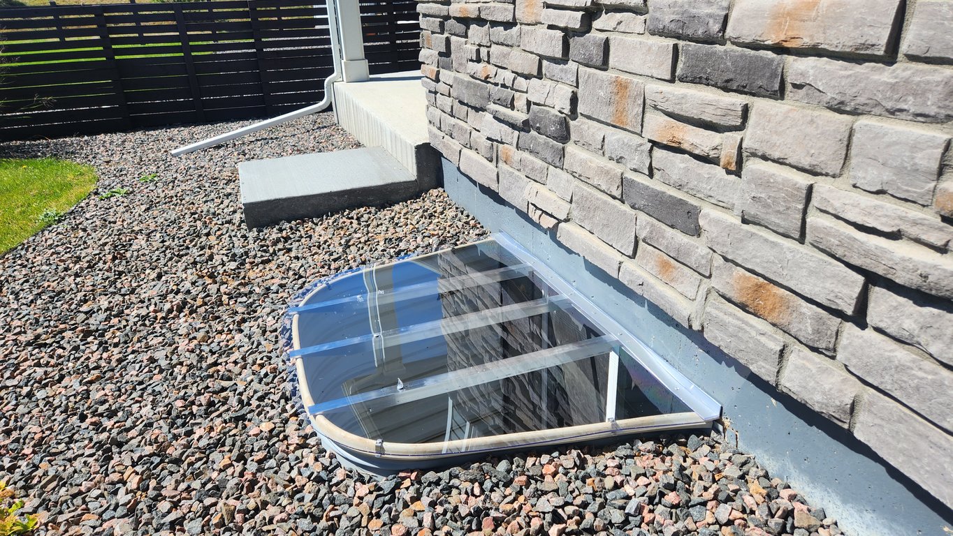 Custom clear window well cover installed in New Lenox Illinois for patios decks and landscaping areas
