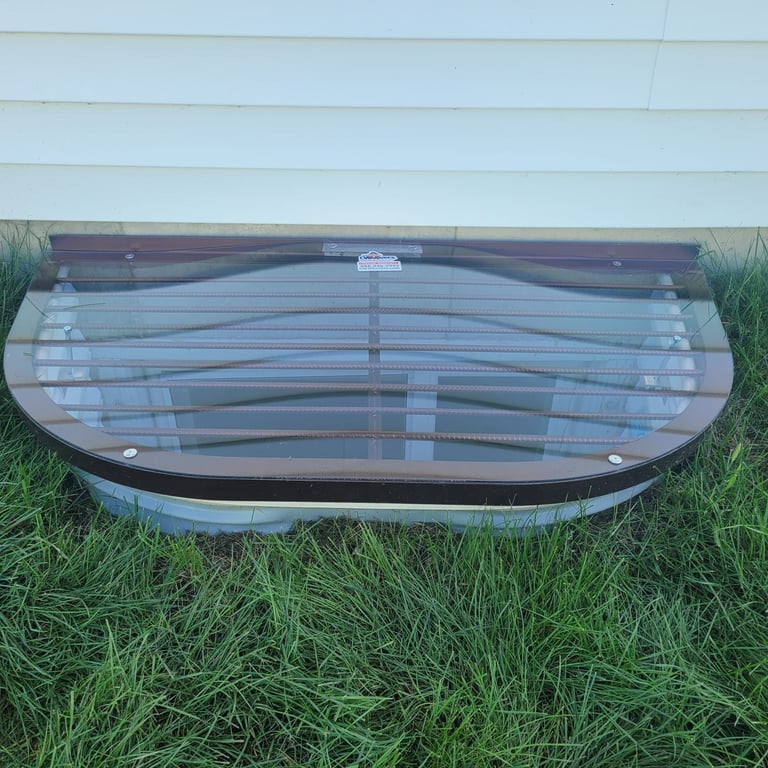 Overlay sloped clear polycarbonate window well cover installed in Parker Colorado over existing grate or frame