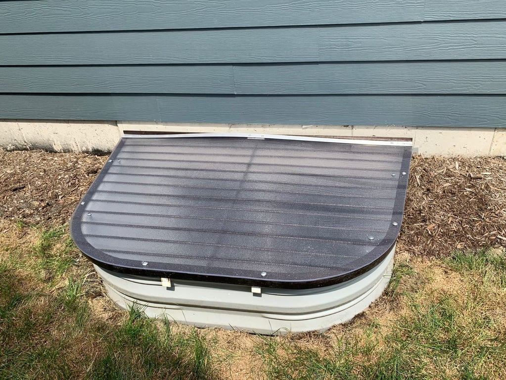 Overlay frosted window well cover installed in Plainfield Illinois over an existing metal grate for protection and privacy