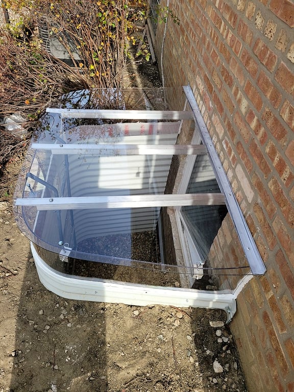 Clear polycarbonate extension riser and custom window well cover installed in Louisville Colorado for added height and window clearance