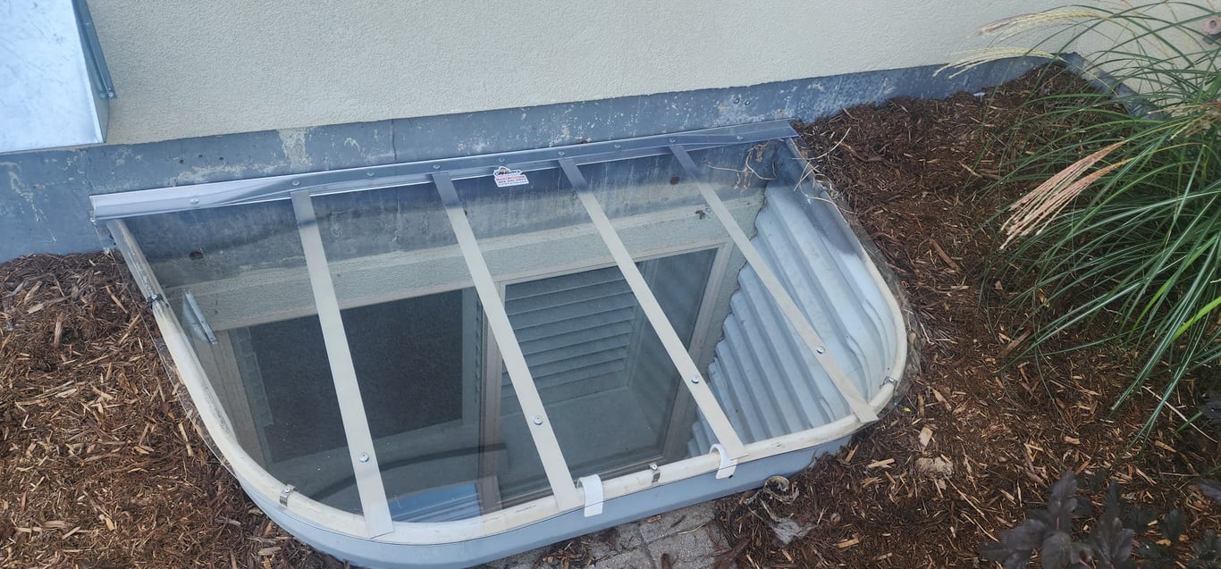Large sloped clear polycarbonate window well cover 66x38 with locks made onsite in Geneva Illinois