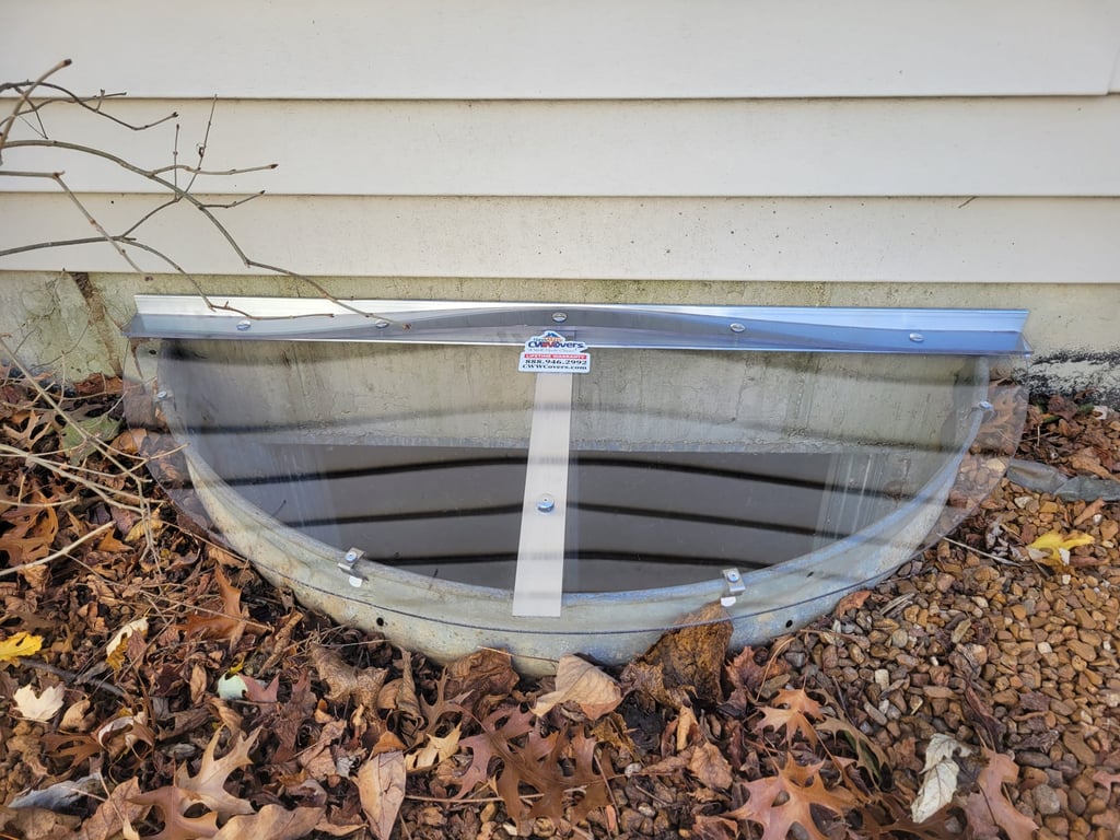 Sloped clear polycarbonate window well cover 40x16 with clips installed in Batavia Illinois