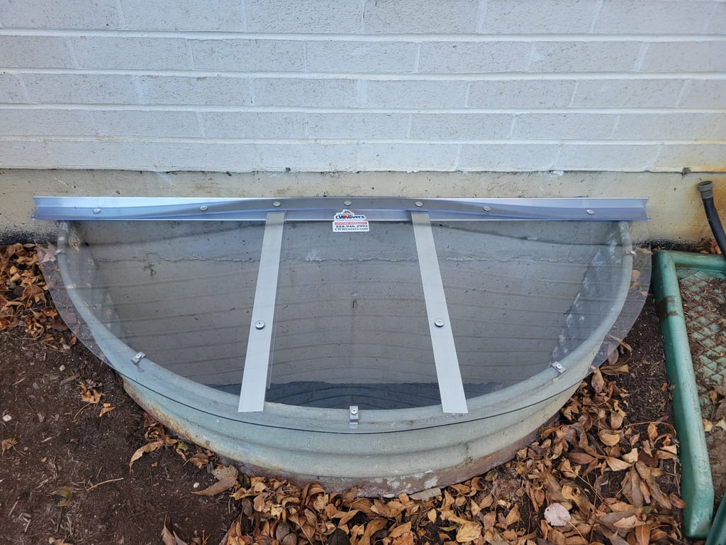 Custom clear polycarbonate window well cover with clips made onsite in Lone Tree Colorado
