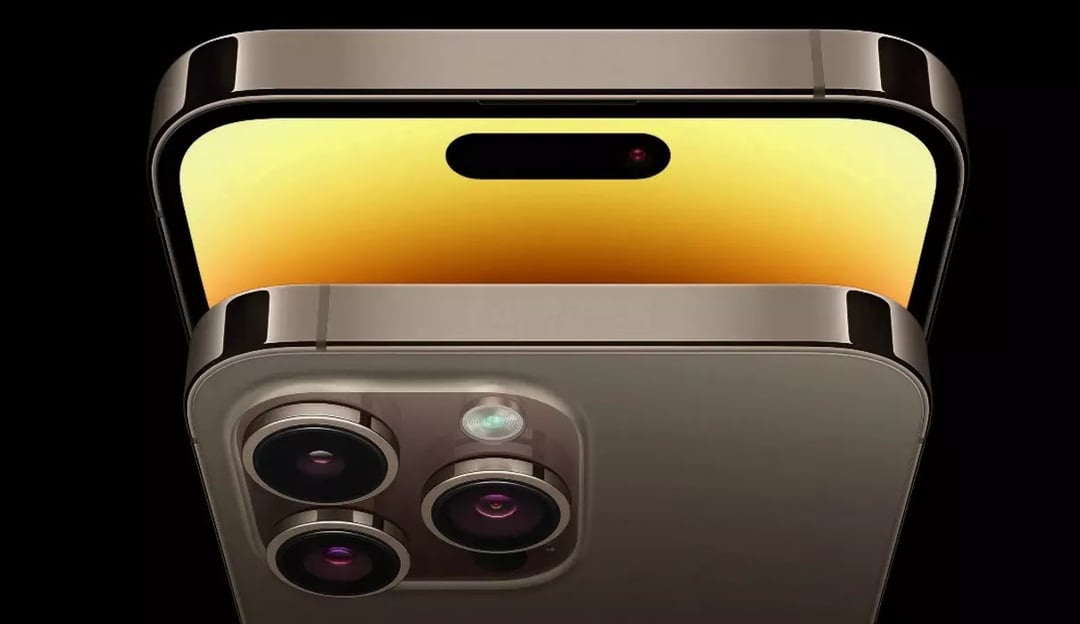 Close-up graphic of a gold iPhone showing the triple-camera array with sensor and flash, stacked beneath the display featuring the pill-shaped Dynamic Island.
