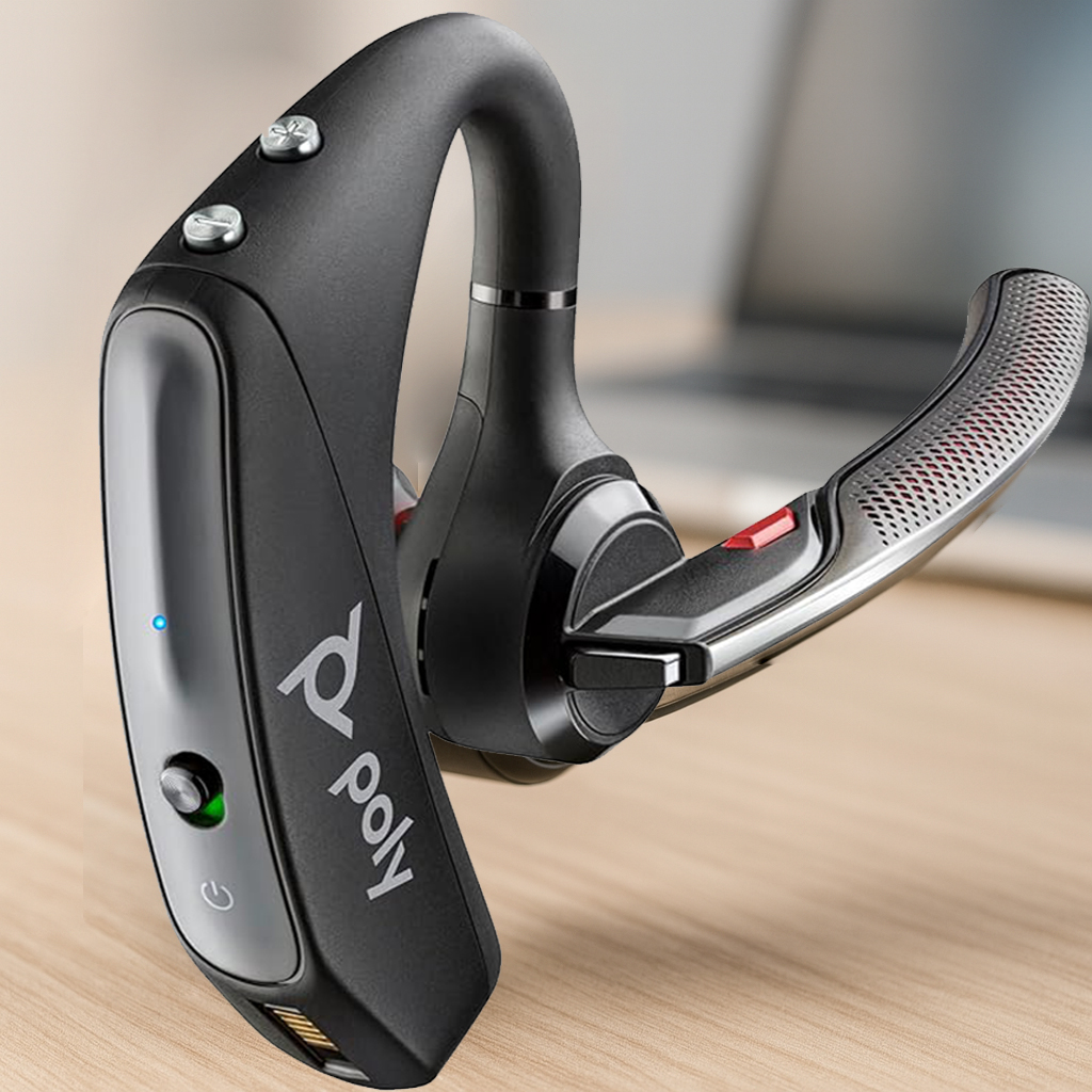 Ultra-realistic photo of the Poly Voyager 5200 mono Bluetooth headset with boom mic on a clean modern desk, softly blurred laptop in the background and natural lighting for a premium, modern look.