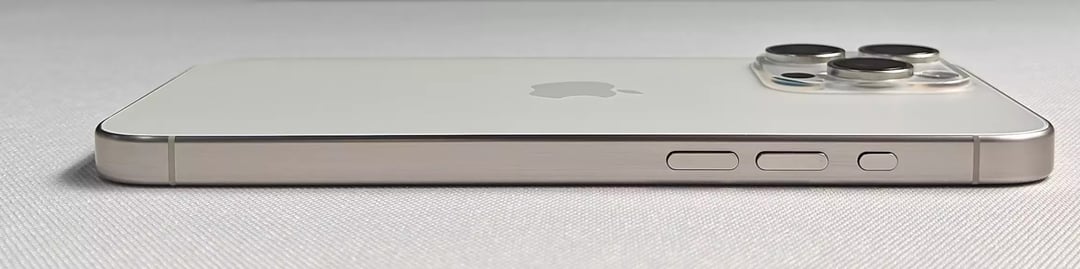 Ultra-wide side profile of a silver iPhone showing the flat titanium frame with volume buttons and Action button, plus the raised triple-camera module.