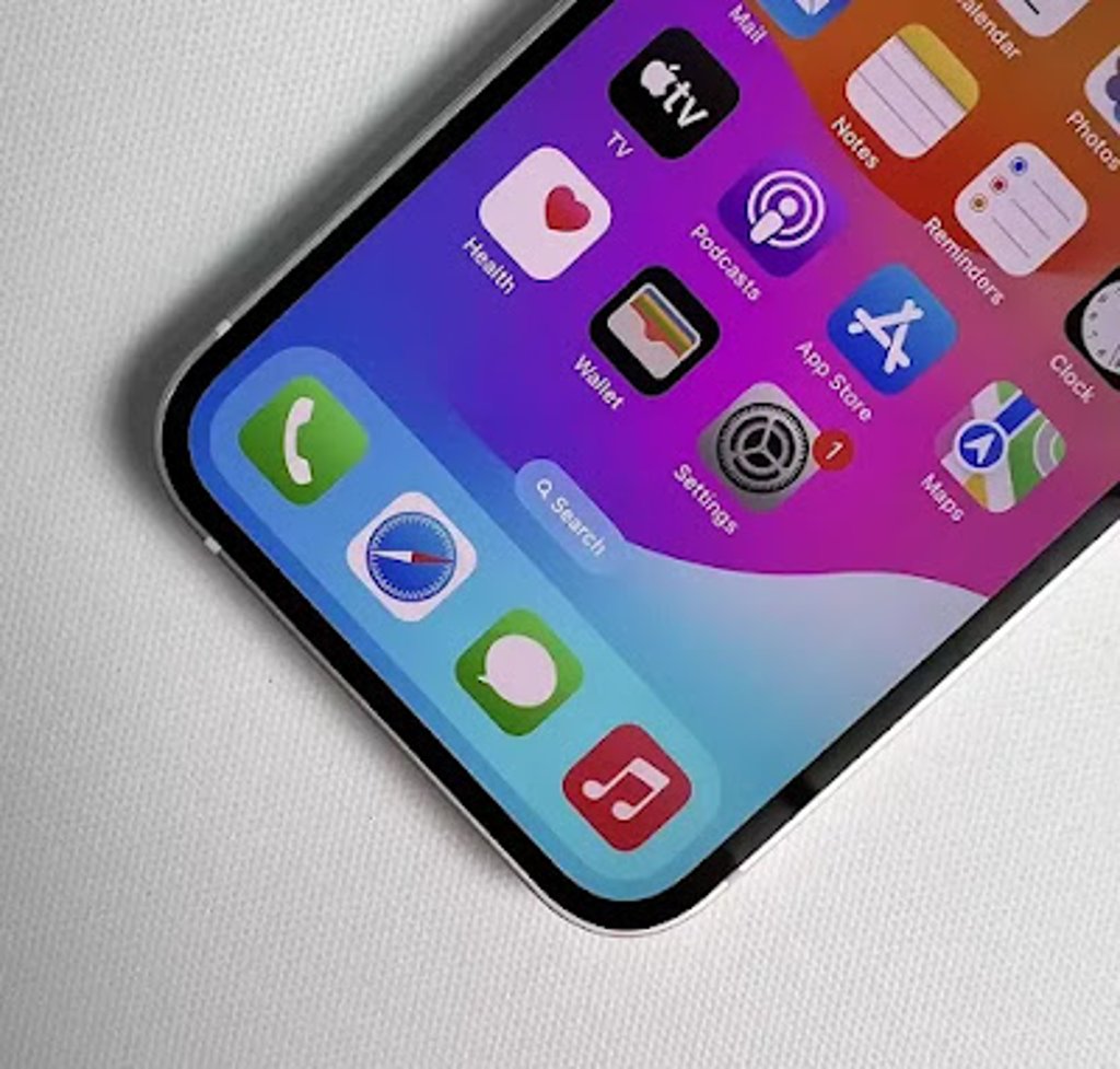 Close-up of the Apple iPhone 13 display showing colorful iOS app icons on the home screen, highlighting the edge-to-edge OLED screen and flat aluminum frame.