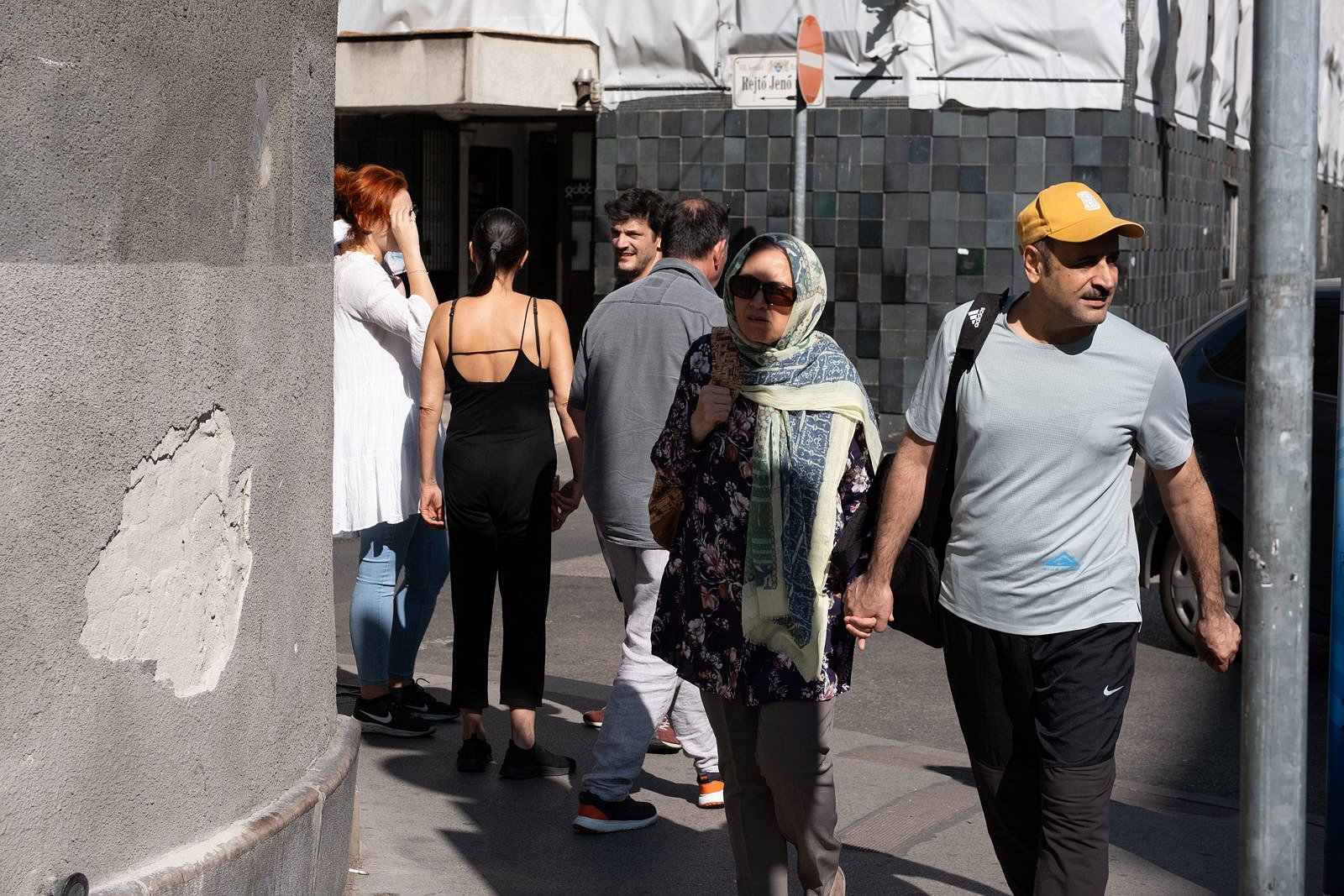 Older couple walking past group of young people