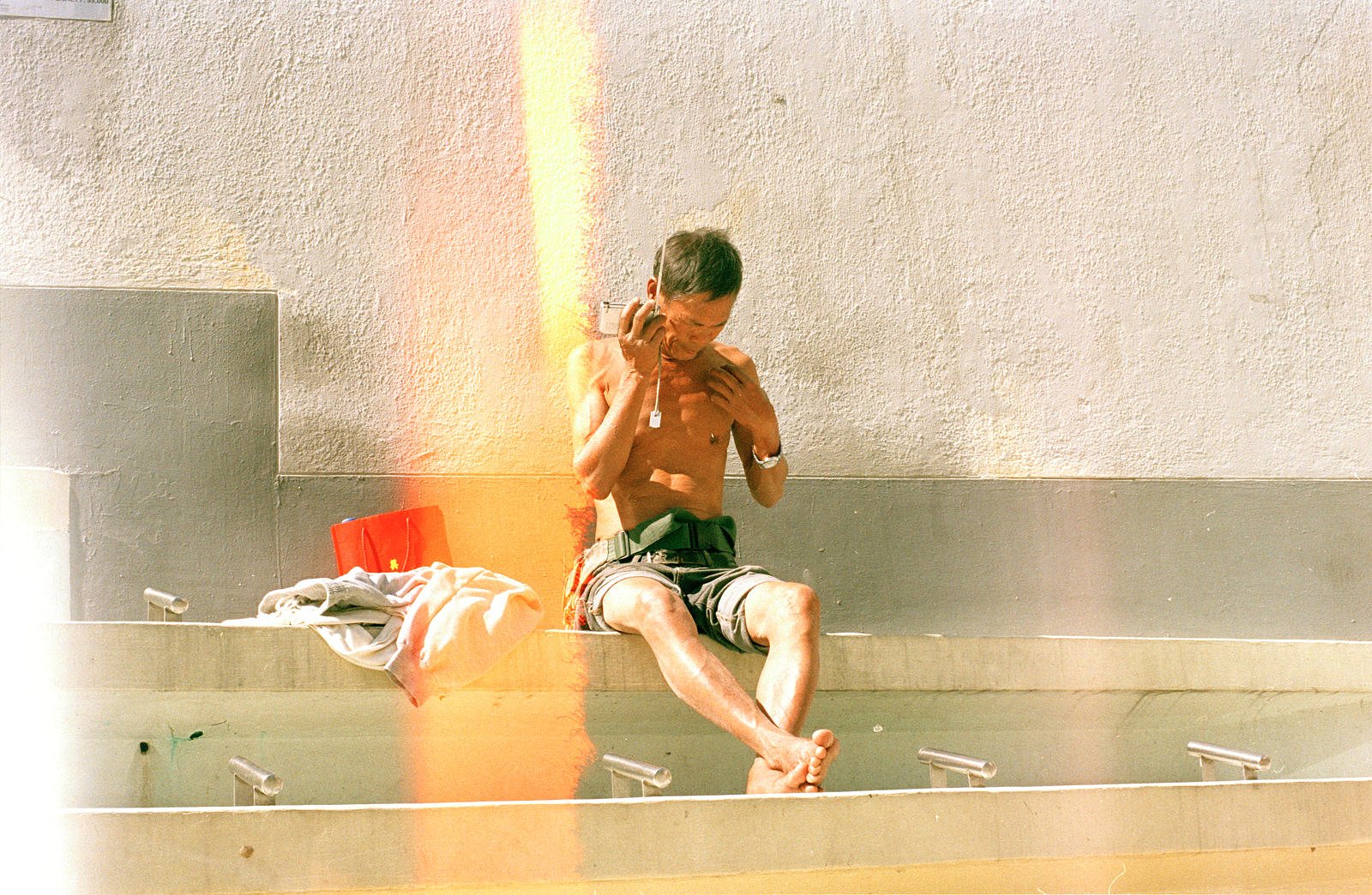 Topless man listening to radio