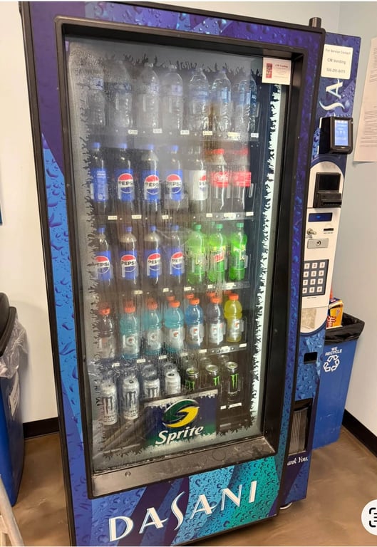 Glass-front beverage vending machine stocked with cold drinks