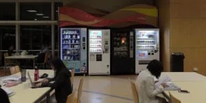 Vending machines in a workplace cafeteria providing snacks and drinks for employees in Dallas.