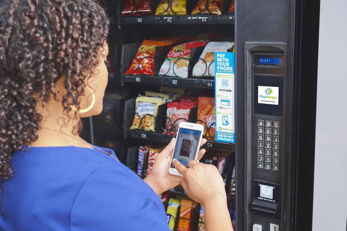 Employee making a cashless payment at a workplace vending machine