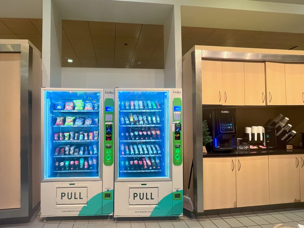 Hybrid employees enjoying snacks and coffee together around a Dallas office pantry