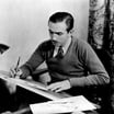 Walt Disney seated at a drawing board, sketching an animated character, circa 1933.