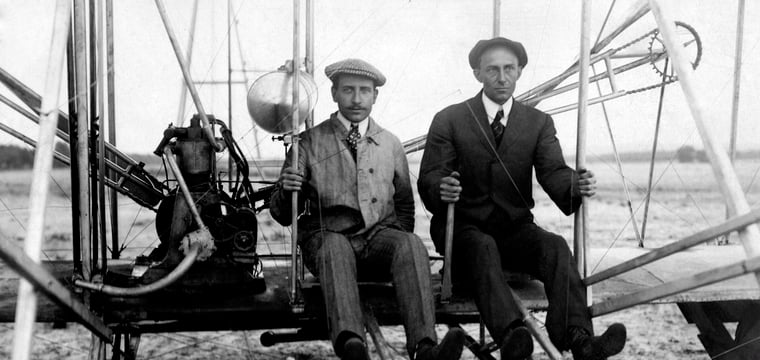 Wilbur and Orville Wright posed together in a black and white photograph, circa 1910.