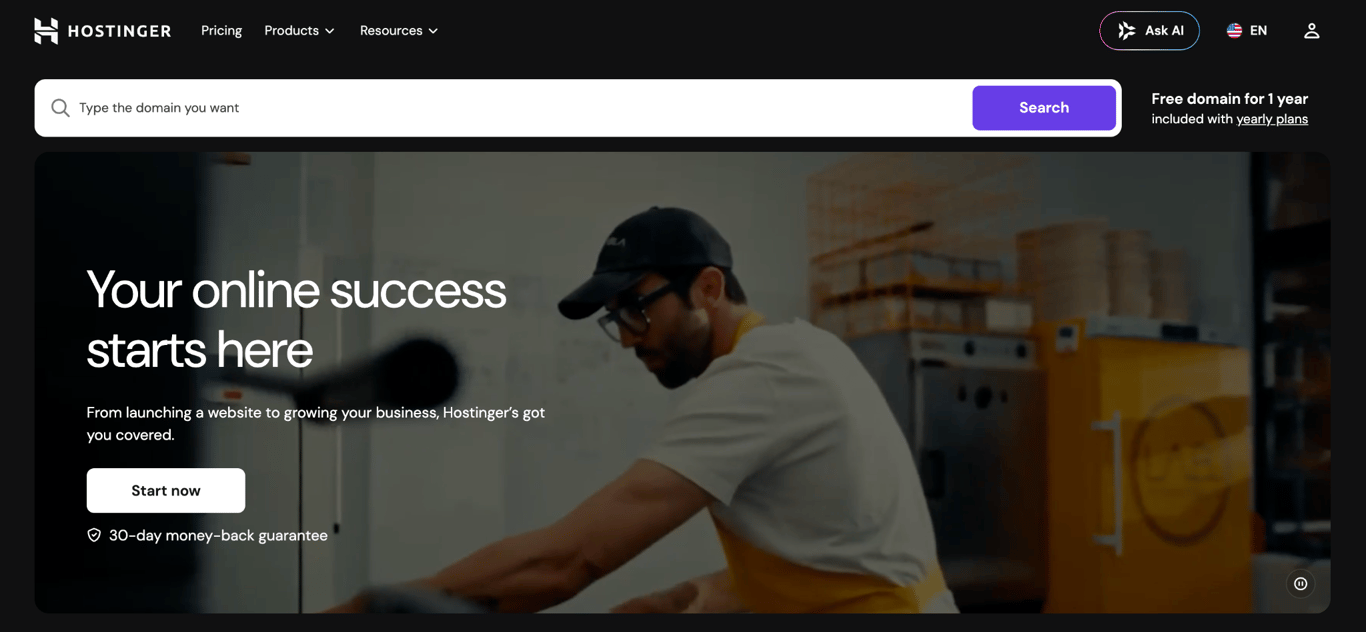 Hostinger homepage with a domain search bar, a free domain for one year offer, and a Start now button with a 30-day money-back guarantee