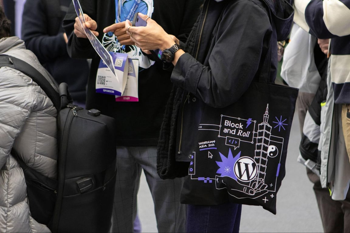 WordCamp Asia attendee holding Hostinger tote bag