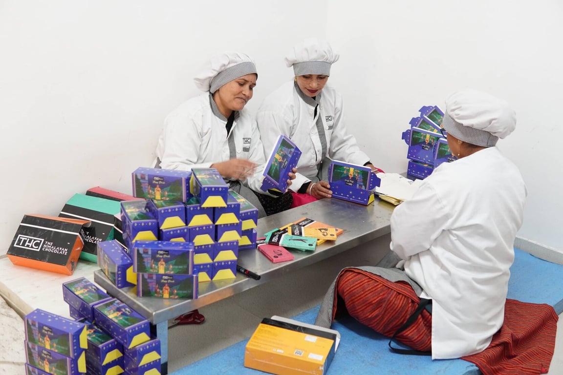 Three women packing chocolates