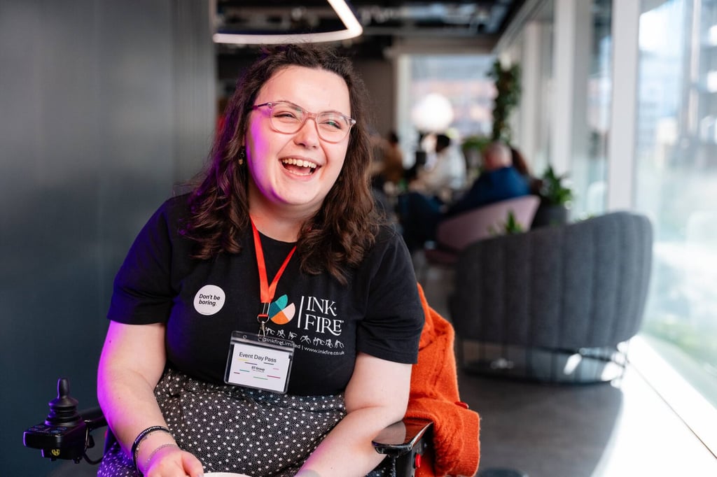 Inkfire co-founder, Imali Chislett, laughing at an event, wearing an Inkfire branded t-shirt