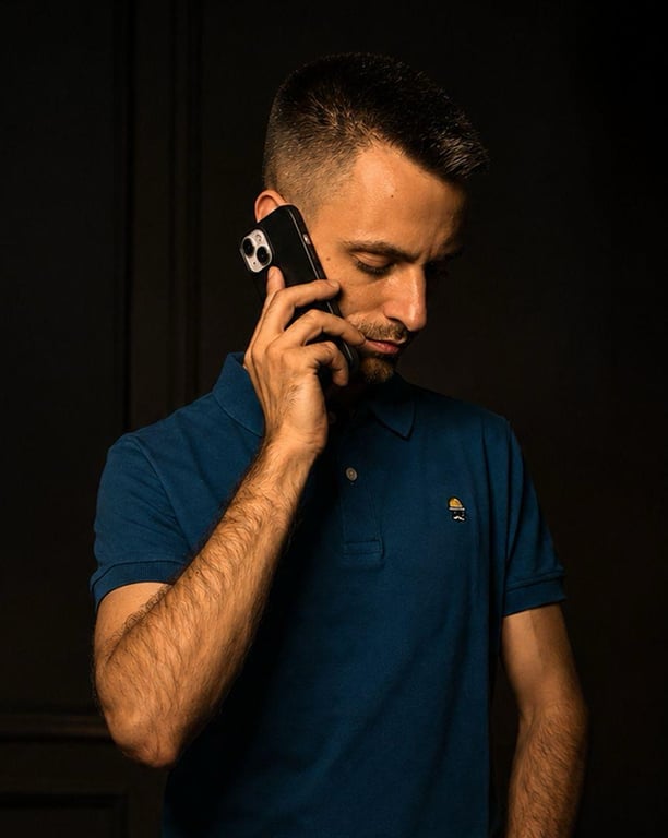 Manuel Ferre, founder of EME EFE ESTUDIO, on a phone call against a dark background, wearing a navy polo shirt