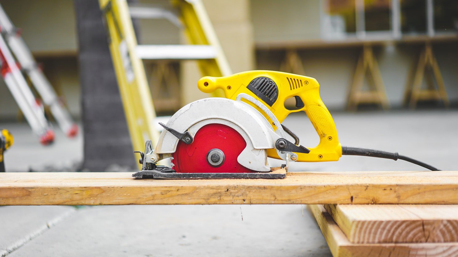 Circular saw on a job site with ladders in the background