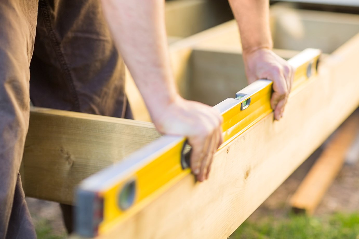 Contractor checking a board with a level