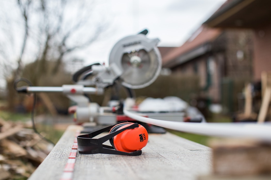 Miter saw and ear protection on a job site