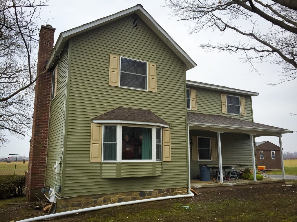 Two-story home with new green siding and bay window