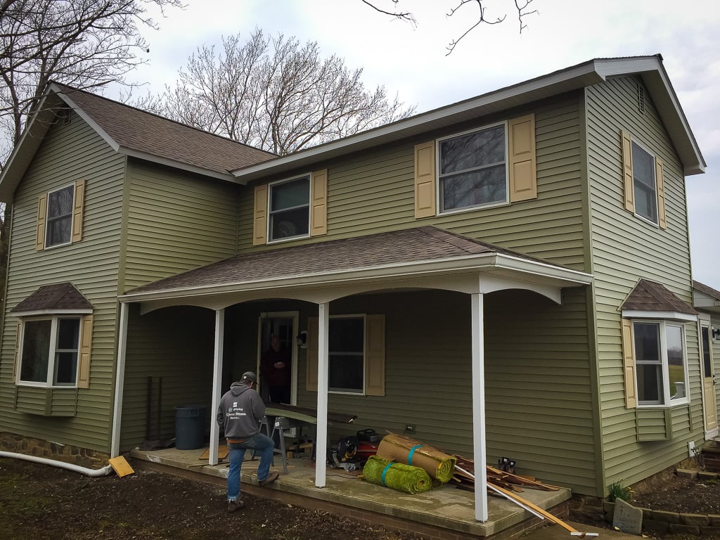 Green siding and front porch on a two-story home
