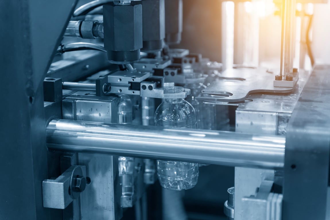 블로우 금형 기계에 플라스틱 페트병이 제작되고 있는 사진