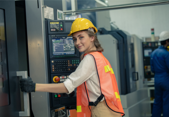 작업자가 CNC 기계를 점검하고 있는 장면