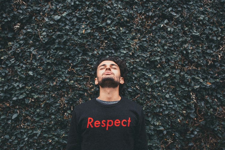 A man wearing a sweatshirt that says 'respect' on the front