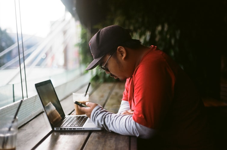 A man in a coffee shop using his laptop