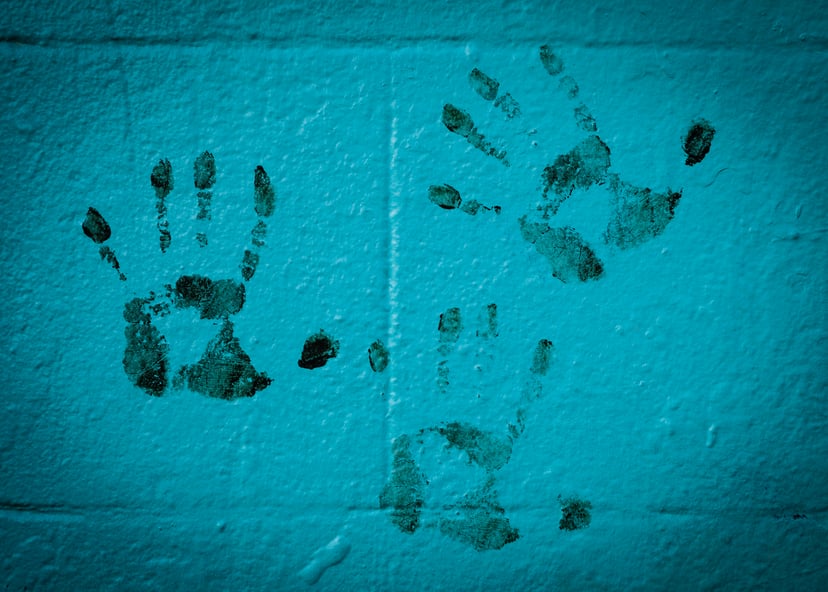Bloody handprints on a blue wall