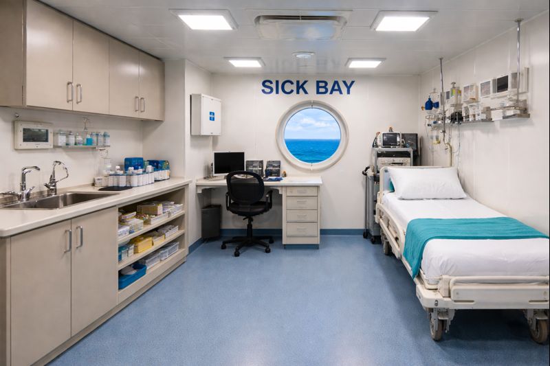 a sick bay on a commercial vessel with a porthole and a view of the ocean