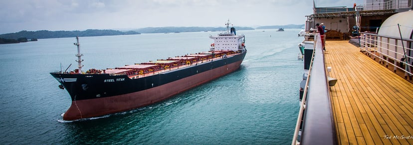 a bulk carrier ship as seen from the deck of a passenger ship