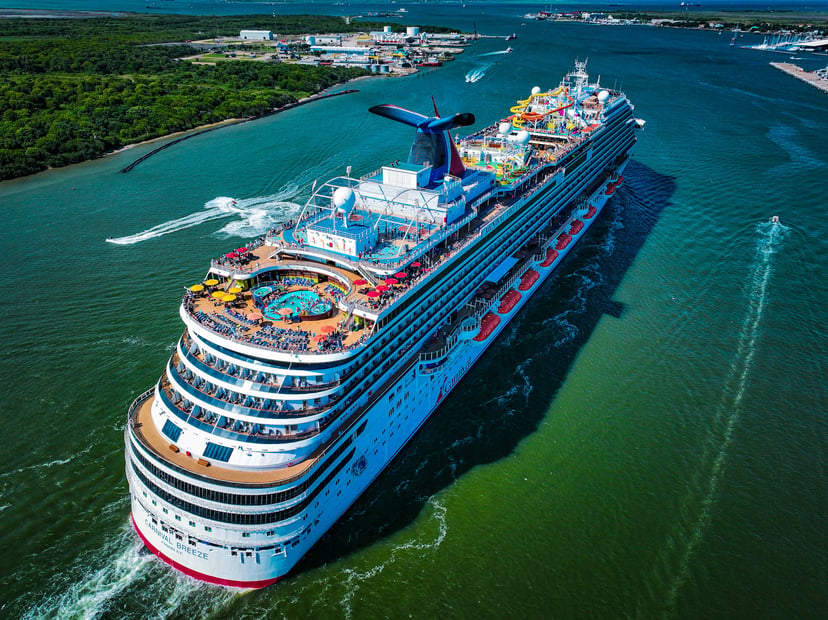 Aerial view of the Carnival Breeze cruise ship as it sails out of a port