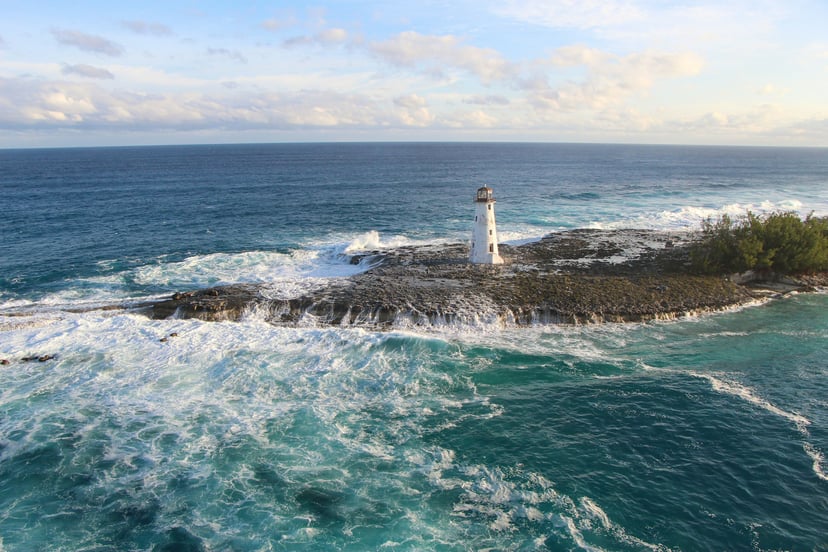 A lighthouse in the Bahamas surrounded by rough seas
