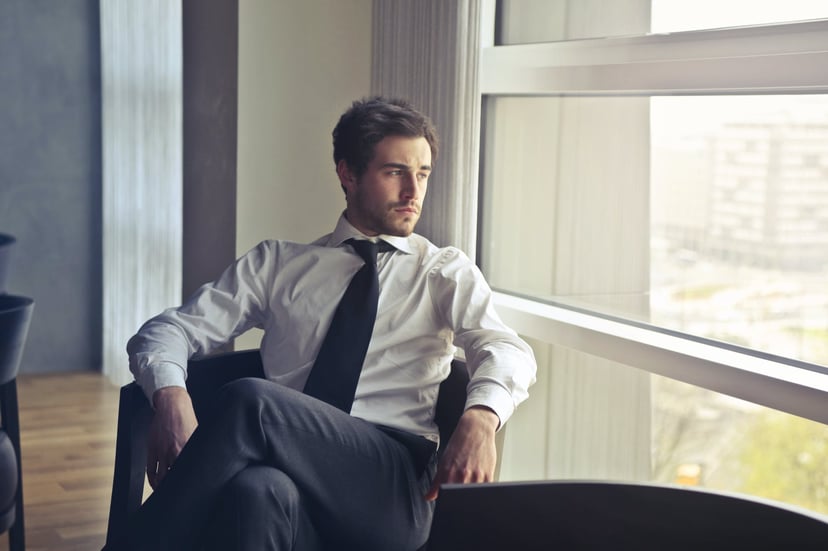 bored looking man gazing out of an office window