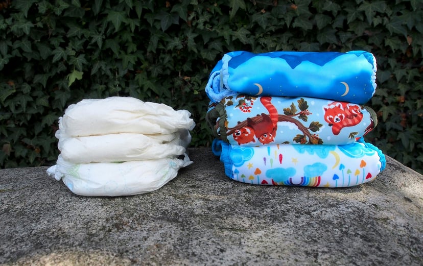 three white and 3 colorful diapers on a stone wall