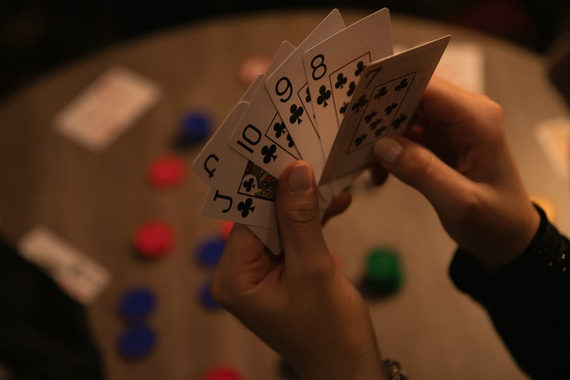 a hand holding six playing cards