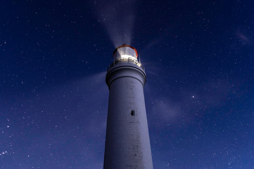 A lighthouse under a starry night sky