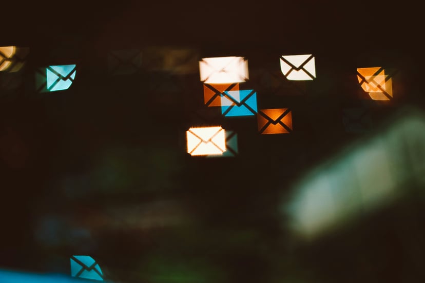 multicolored electronic emails floating on a dark background