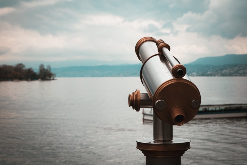 A telescope pointing towards a body of water