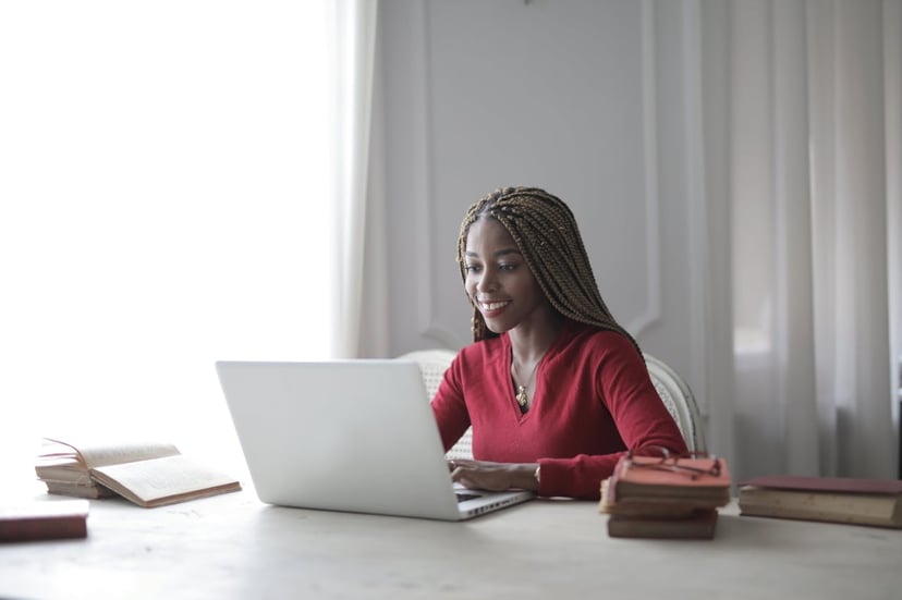 a smiling woman looking at her laptop