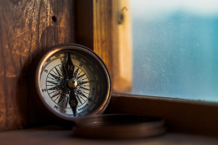 a nautical compass on a window ledge
