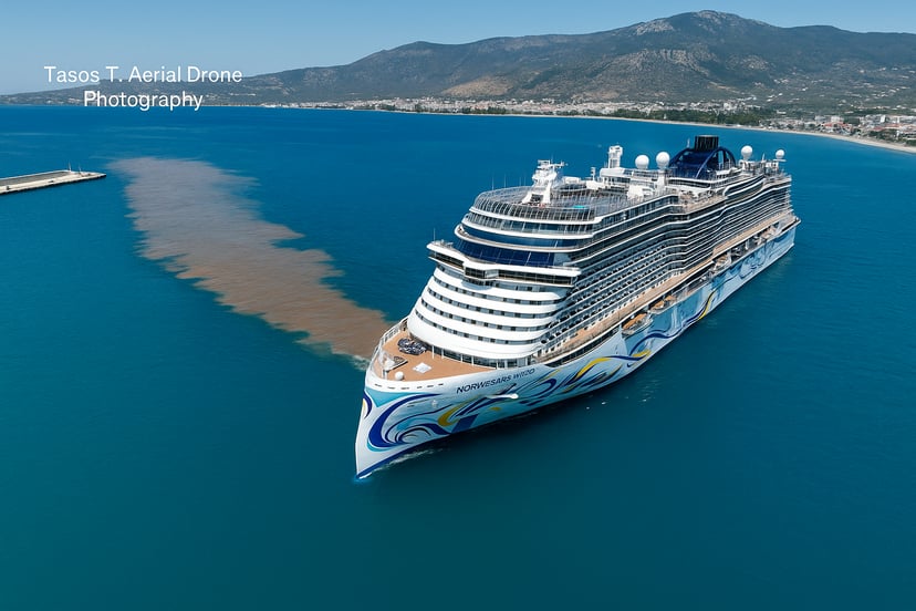 A cruie ship leaving a dirty brown stream in its wake as it leave Volos Port, Greece