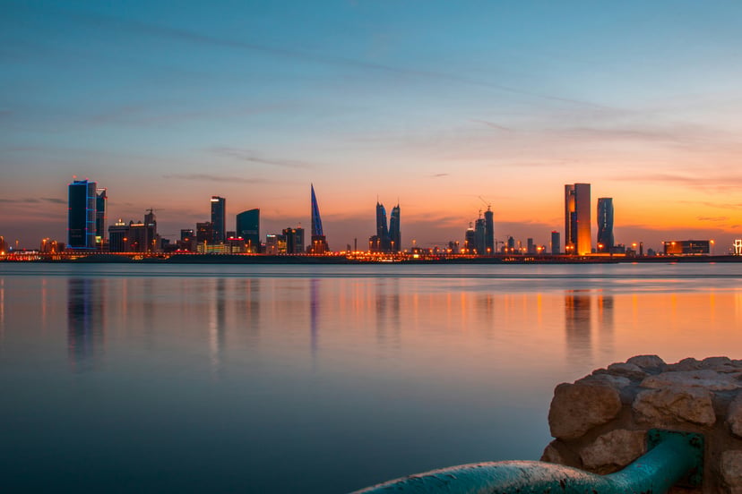 The sun setting over the Bahrain skyline, as seen from the water