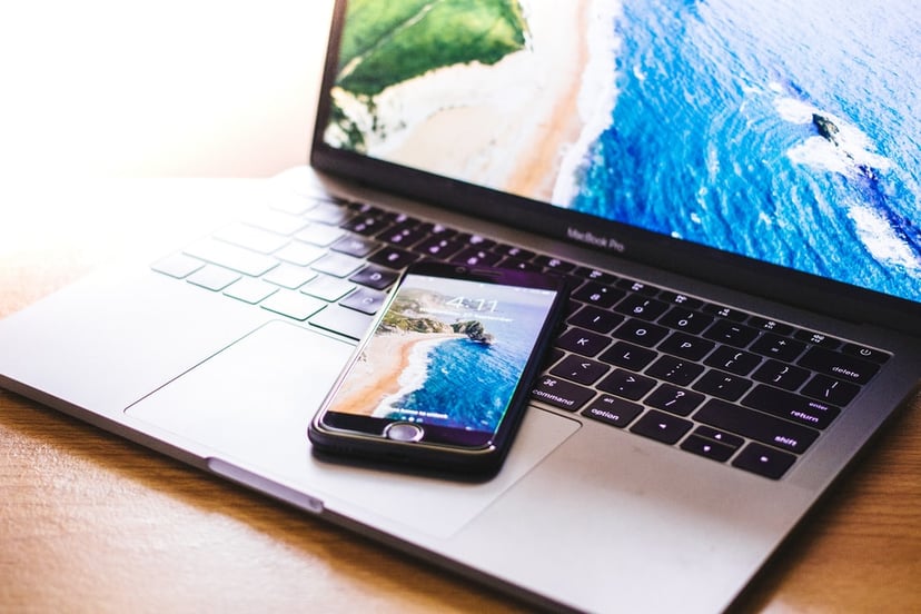 Laptop and iPhone both with the ocean on their screens