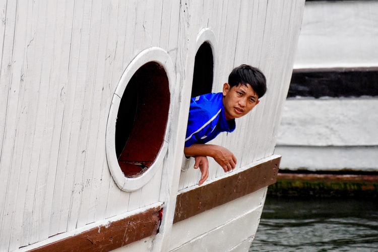 a boy looking out of a porthole